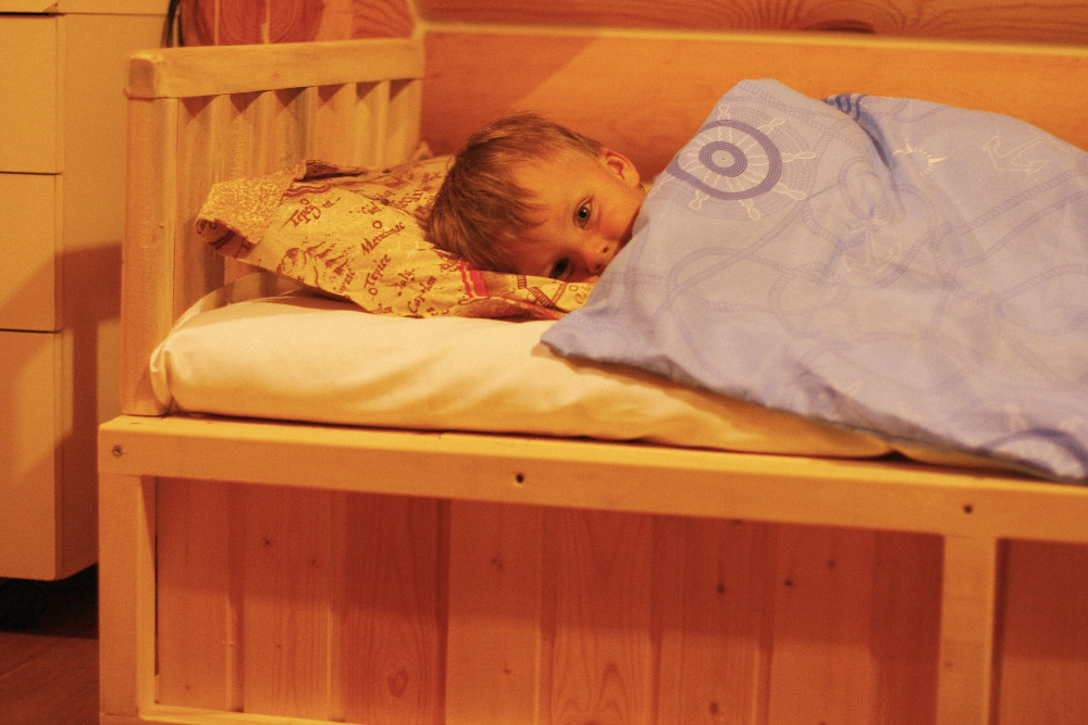 Укрытие детей. Кровать для детей. Спящий ребенок в кровати.